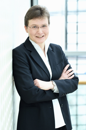 Offizielles Foto von Carmen Schwab mit weißer Bluse unter blauem Blazer mit verschränkten Armen 