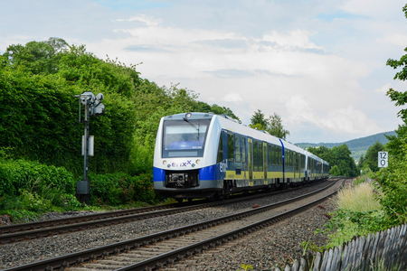 Blaugelber Zug mit erixx-Logo von rechts nach links fahrend