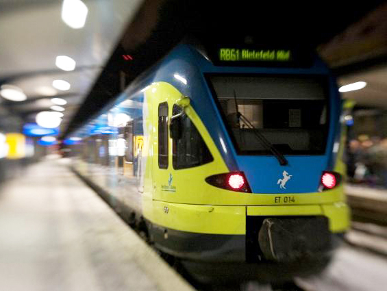Flirt - gelb-blaue Bahn an Haltestelle