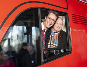 Hendrik Wüst, NRW-Verkehrsminister (links) und Reinhold Hilbers, niedersächsischer Finanzminister (rechts) am Fenster des Führerstandes eines roten Doppelstock-Steuerwagens   