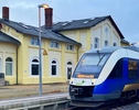 Blau-weiß-gelber Lint-Zug, der für das Unternehmen Start fährt, am Halt Soltau