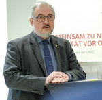 Christian Berndt am Rednerpult leicht nach rechts gewandt in grauem anzug mit hellblauem Hemd und mittelblauer Kravatte