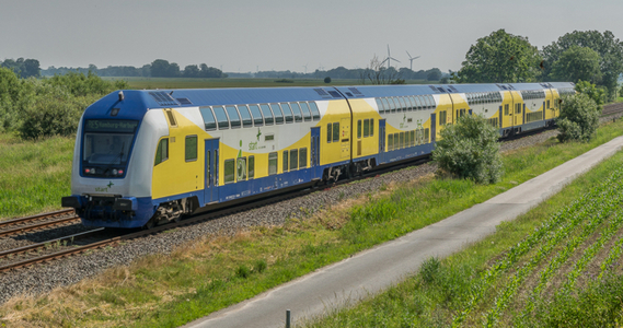 blau-weiss-gelber Zug der Regionalverkehre Start Deutschland GmbH schräg von vorne nach links fahrend