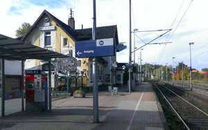 Eindruck von der Station in Augustfehn von vor dem Umbau mit seitlicher Sicht auf Gebäude und Blick auf die Schienen vom Wetterschutzhäuschen aus