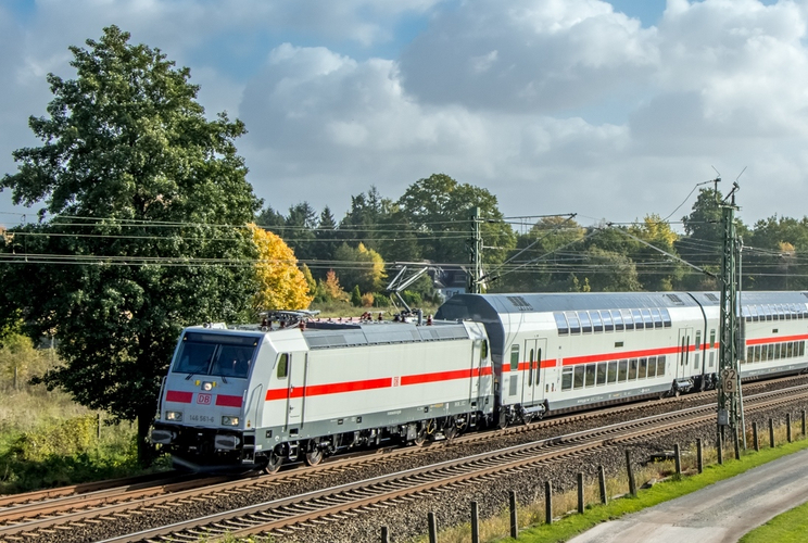 Moderner silberfarbener IC mir rotem Mittelstreifen von DB Fernverkehr mit Lok, nach links fahrend