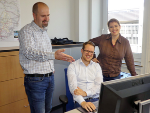Die LNVG-Angebotsplaner (von links nach rechts): Jan Krok, Sebastian Neustock, Katrin Berens an einem Schreibtisch vor einem Computer