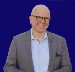Porträt des neuen Bereichsleiters Jörg Kinke auf blauem Hintergrund