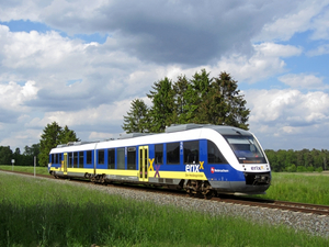 Blauweißgelber SPNV-Triebwagen für das Unternehmen erixx im Einsatz und in grüner Landschaft von links nach rechts fahrend 