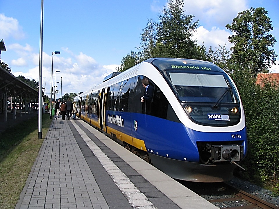 Weiß-blau-gelber Zug der NordWestBahn am Bahnsteig